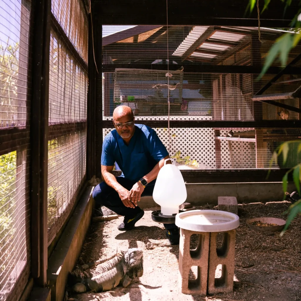 Dr. Walton squatting in his tortoise enclosure